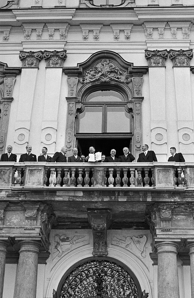 Leopold Figl mit dem frisch unterzeichneten Staatsvertrag auf dem Balkon des Wiener Belvedere, 107340.jpg akg-images / Erich Lessing